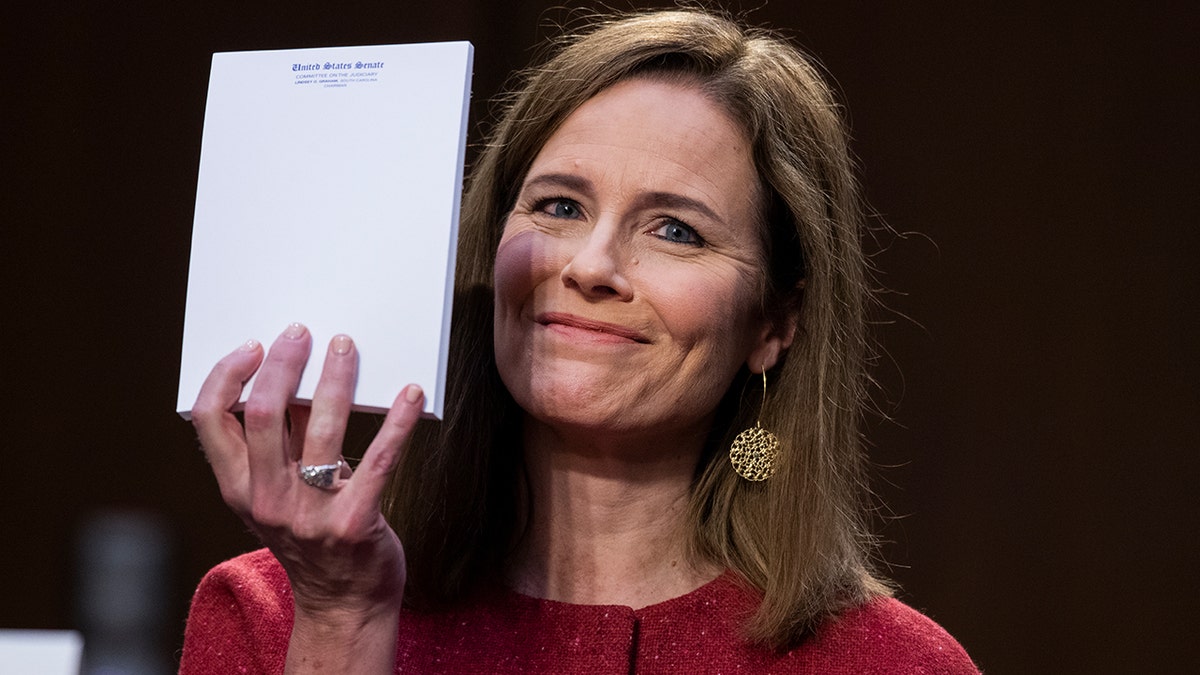 Amy Coney Barrett holds up paper during confirmation hearing