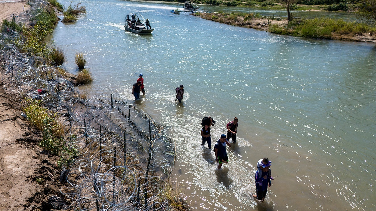 Migrants walking in water