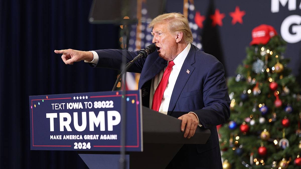 Former President Donald Trump at podium at rally pointing