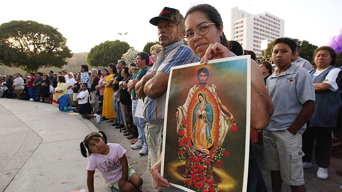 woman holding picture of St. Juan Diego wearing tilma