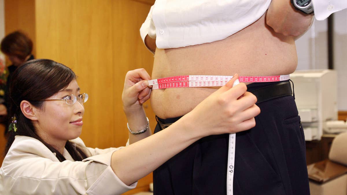 Woman measures a man's waistline