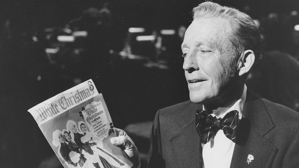 Bing Crosby holding a poster for White Christmas