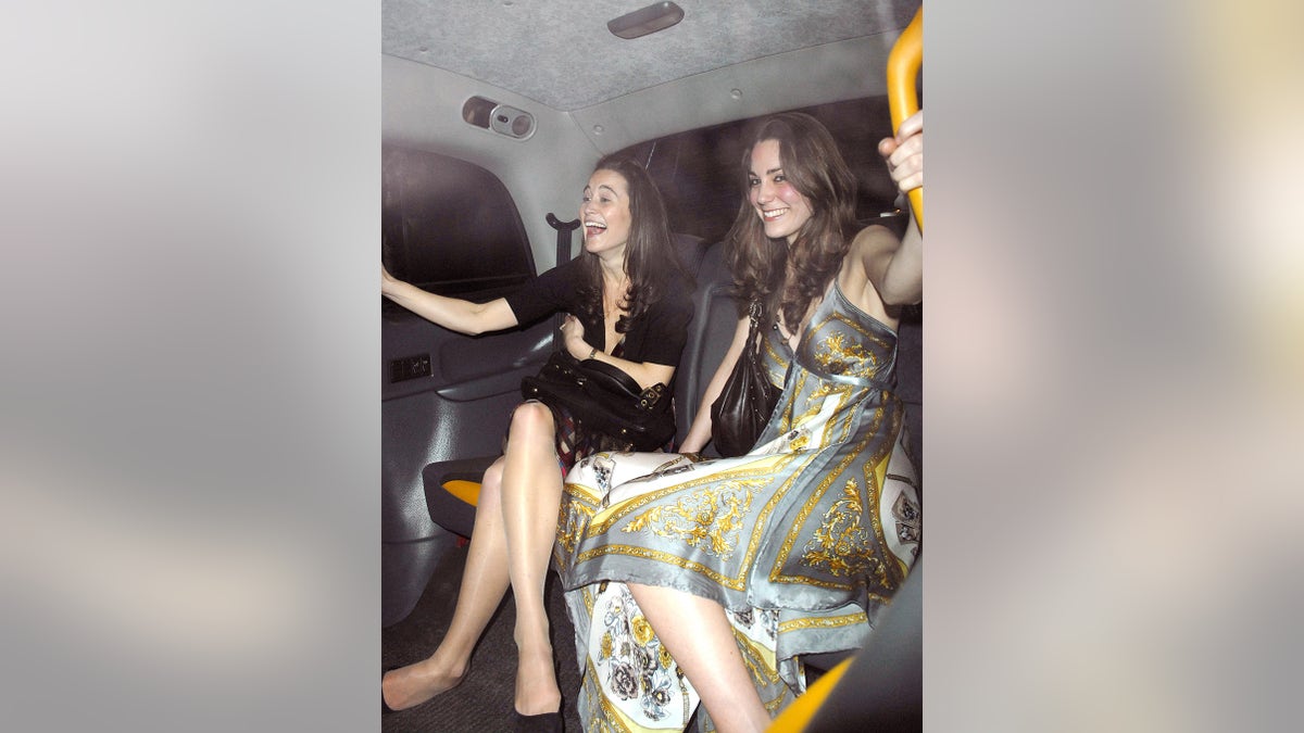 Kate Moddleton wearing a glamorous fown sitting and smiling next to her sister