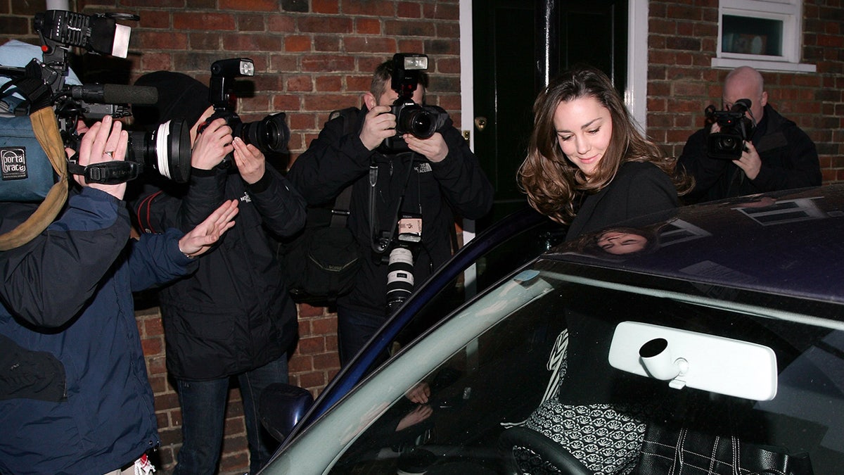 Kate Middleton entering her car as shes surrounded by photographers