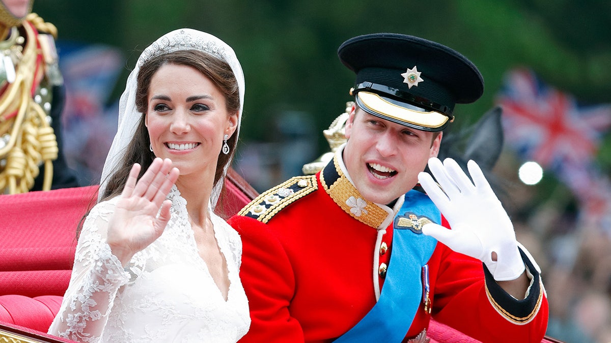 Kate Middleton waving on her wedding day sitting next to Prince William in a red uniform
