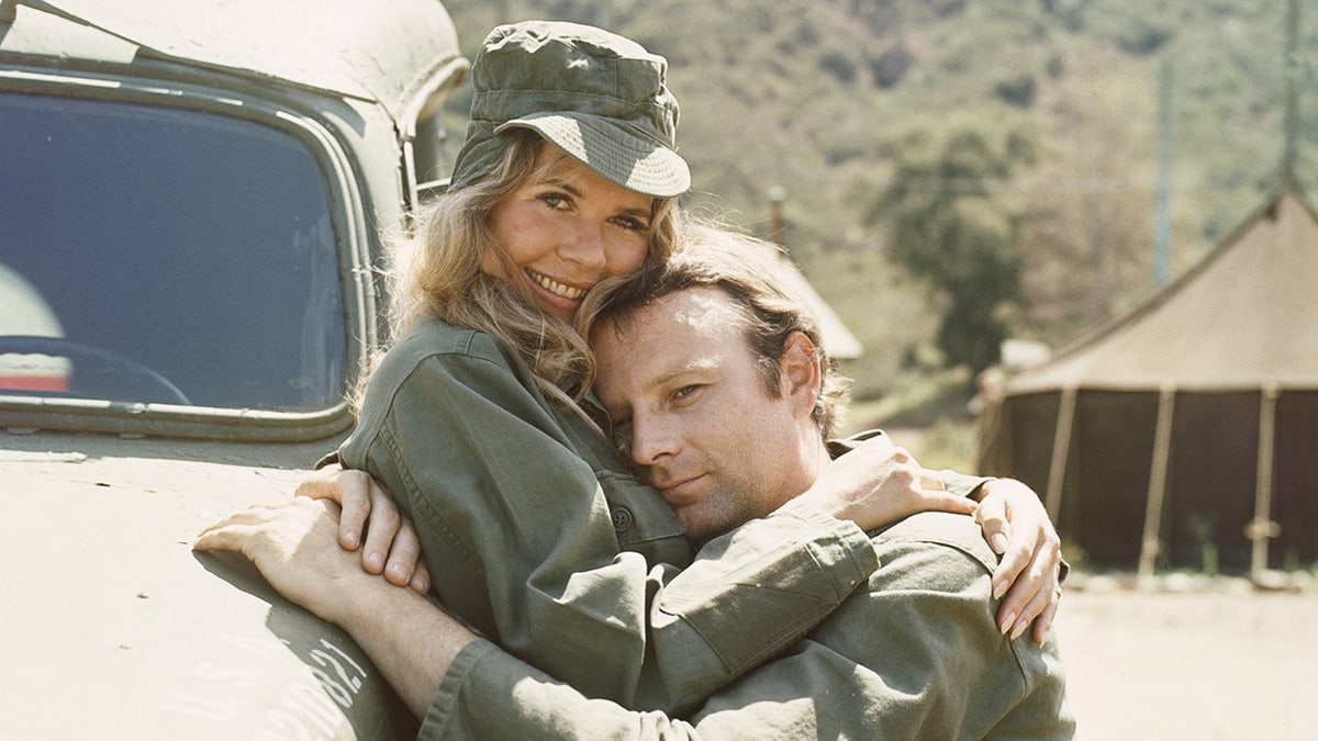 Loretta Swit in character embracing Larry Linville