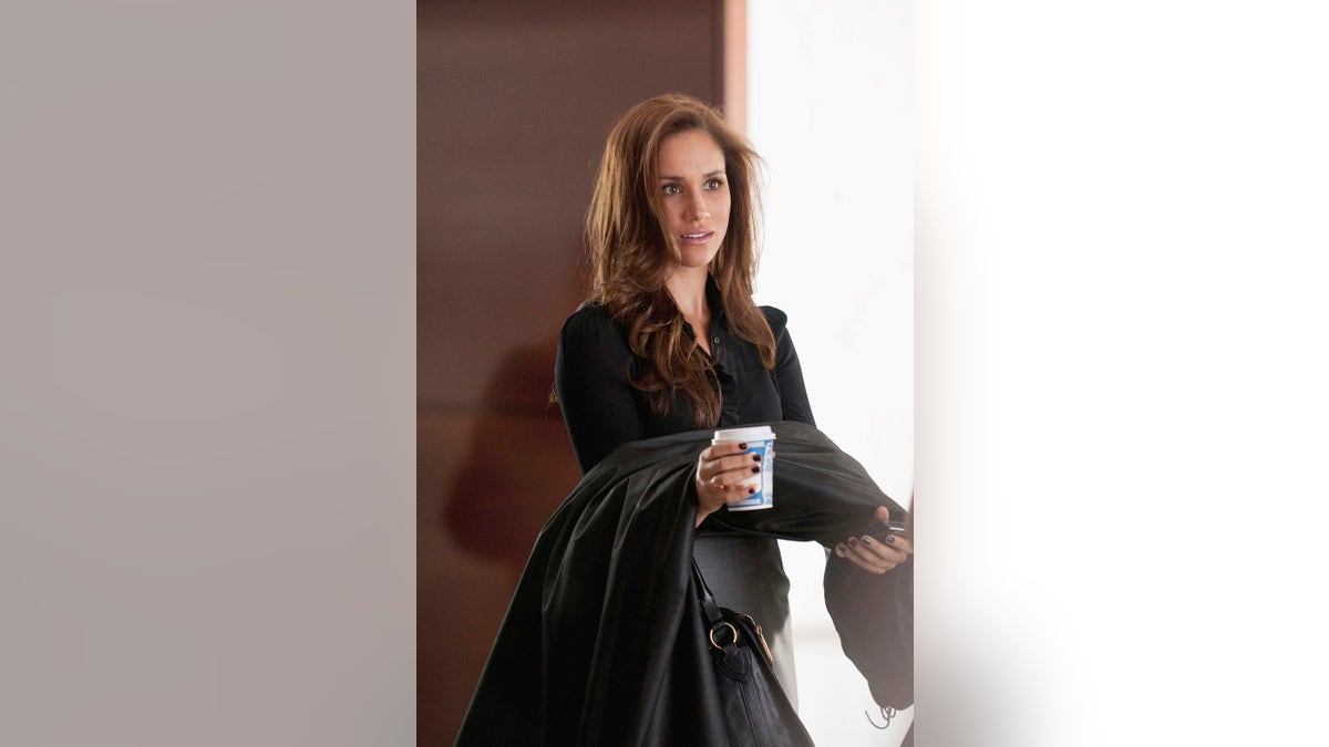 Meghan Markle holding a coffee cup