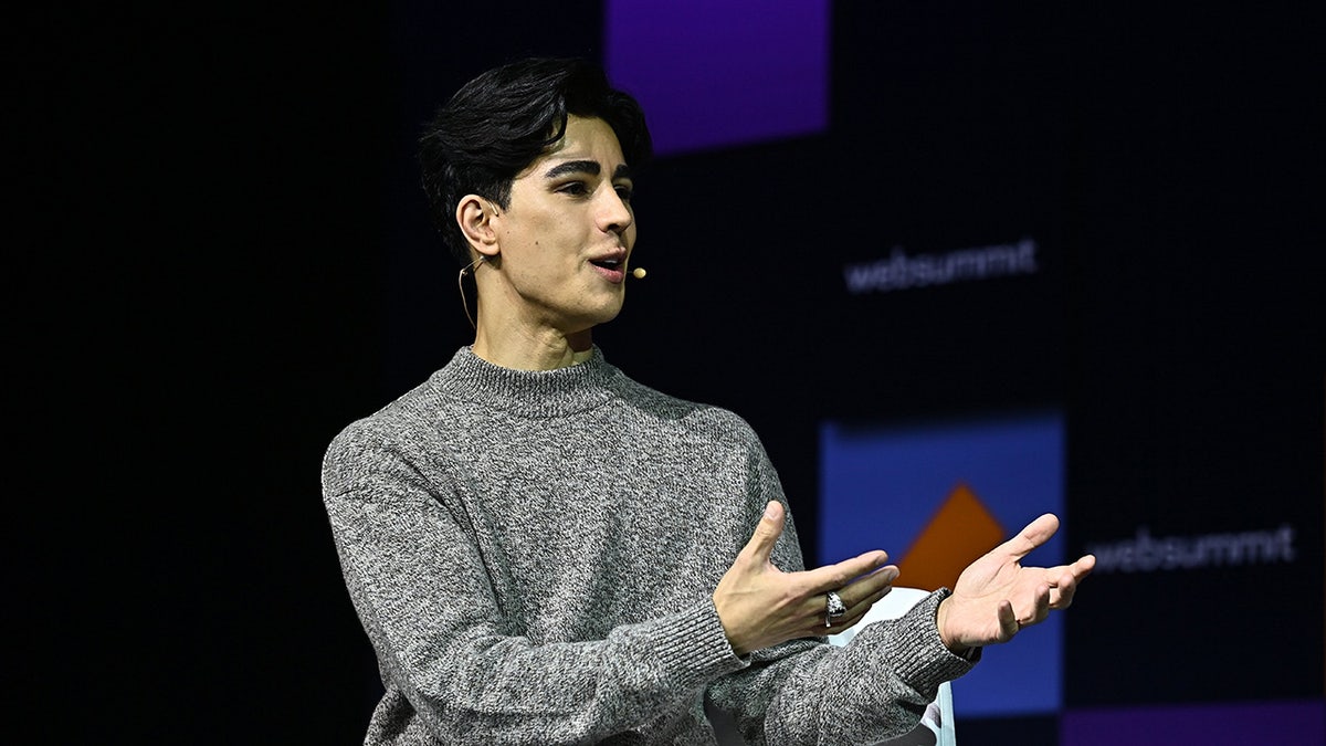 A side profile of Omid Scobie wearing a grey sweater