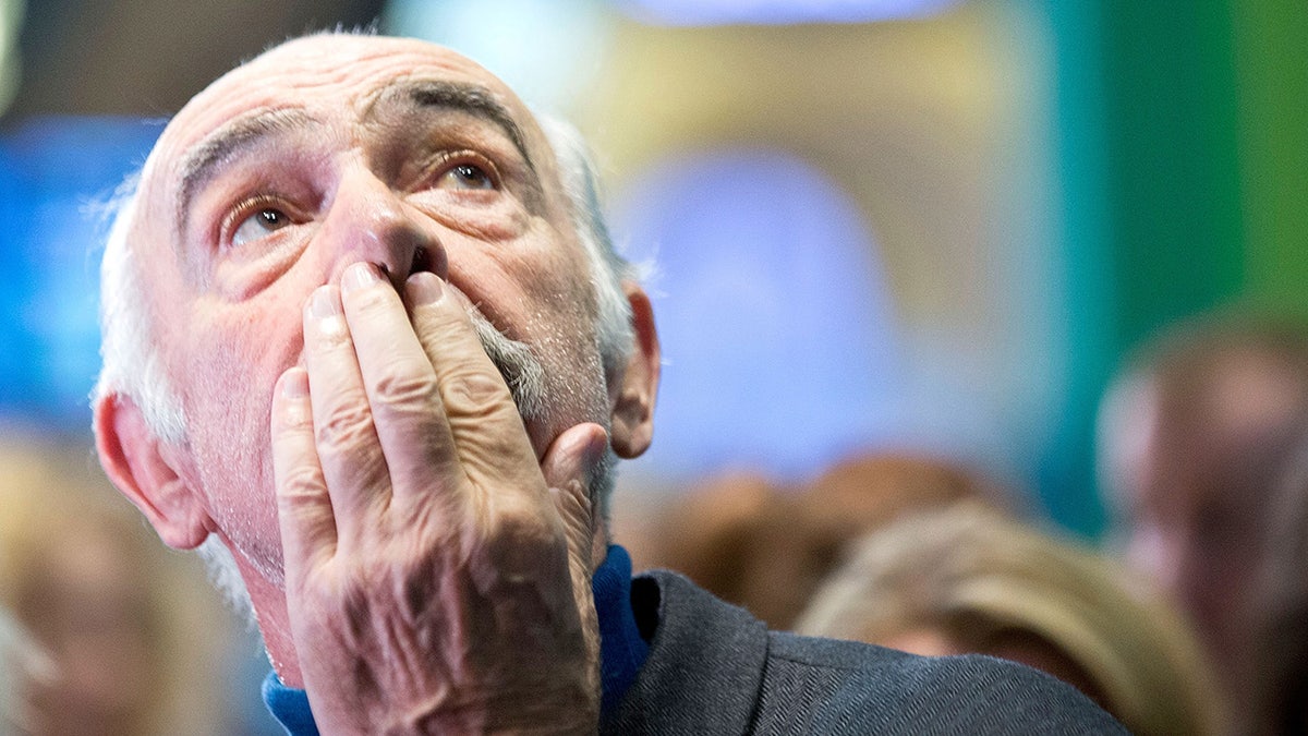 Sean Connery with his hand to his mouth as he looks up