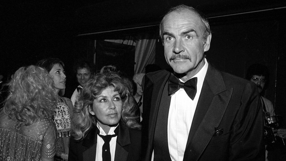 Sean Connery and his wife wearing matching formal suits