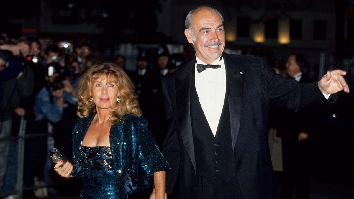 Micheline Roqueburne wearing a sparkling dark blue dress next to Sean Connery smiling in a tux