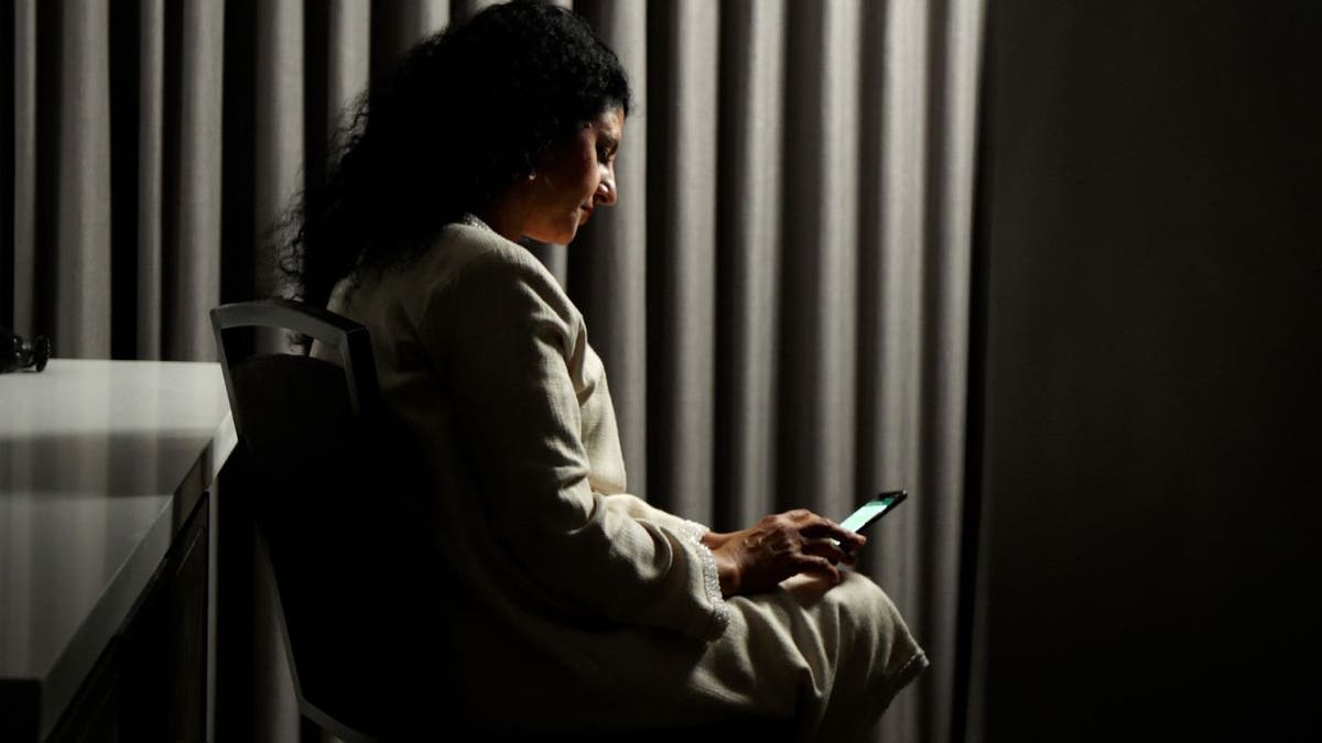 A picture of Hanan Elatr the wife of murdered Saudi journalist Jamal Khashoggi. She is looking down at her phone