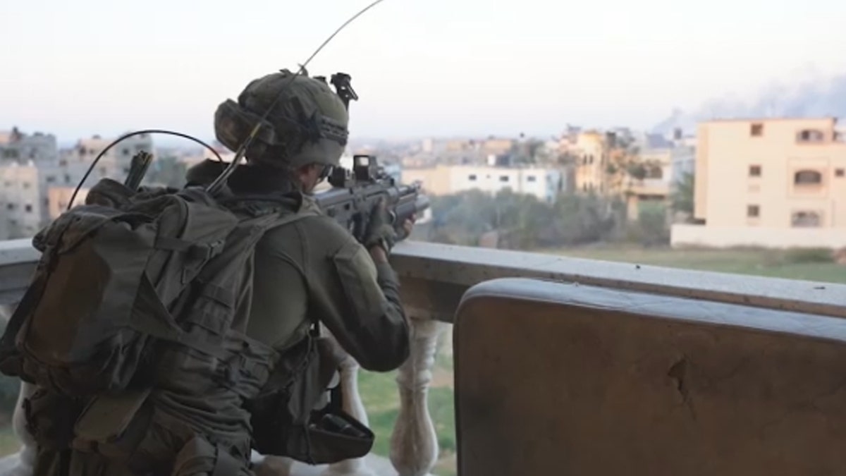 IDF soldier in uniform aiming gun
