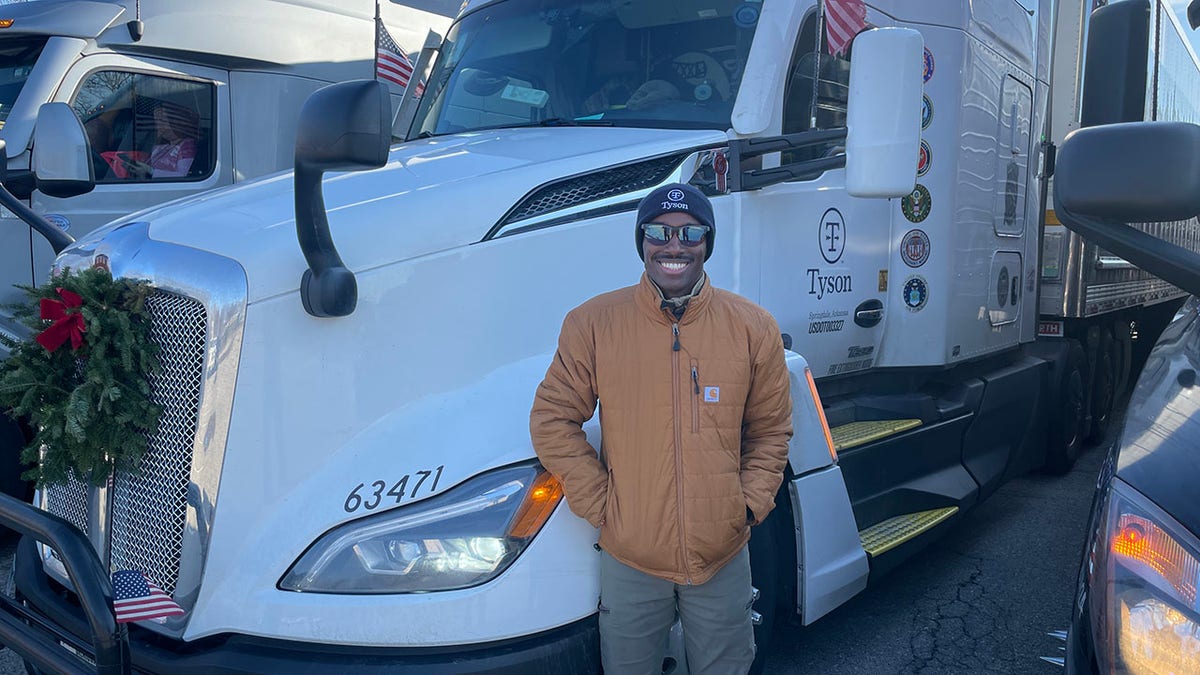 Man standing in front of truck smiling