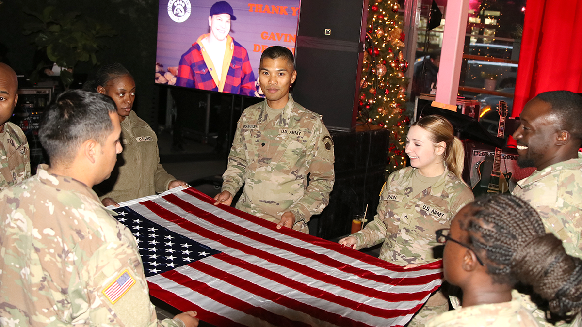 soldiers hold american flag