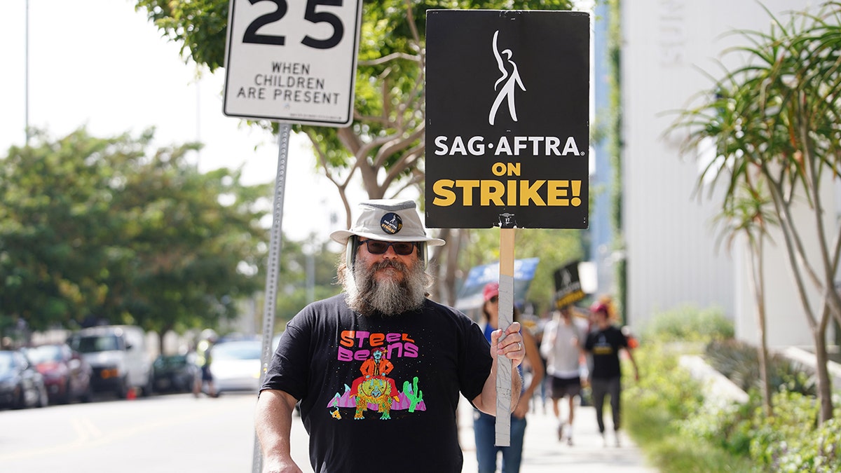 Jack Black segurando cartaz de piquete durante greve SAG-AFTRA