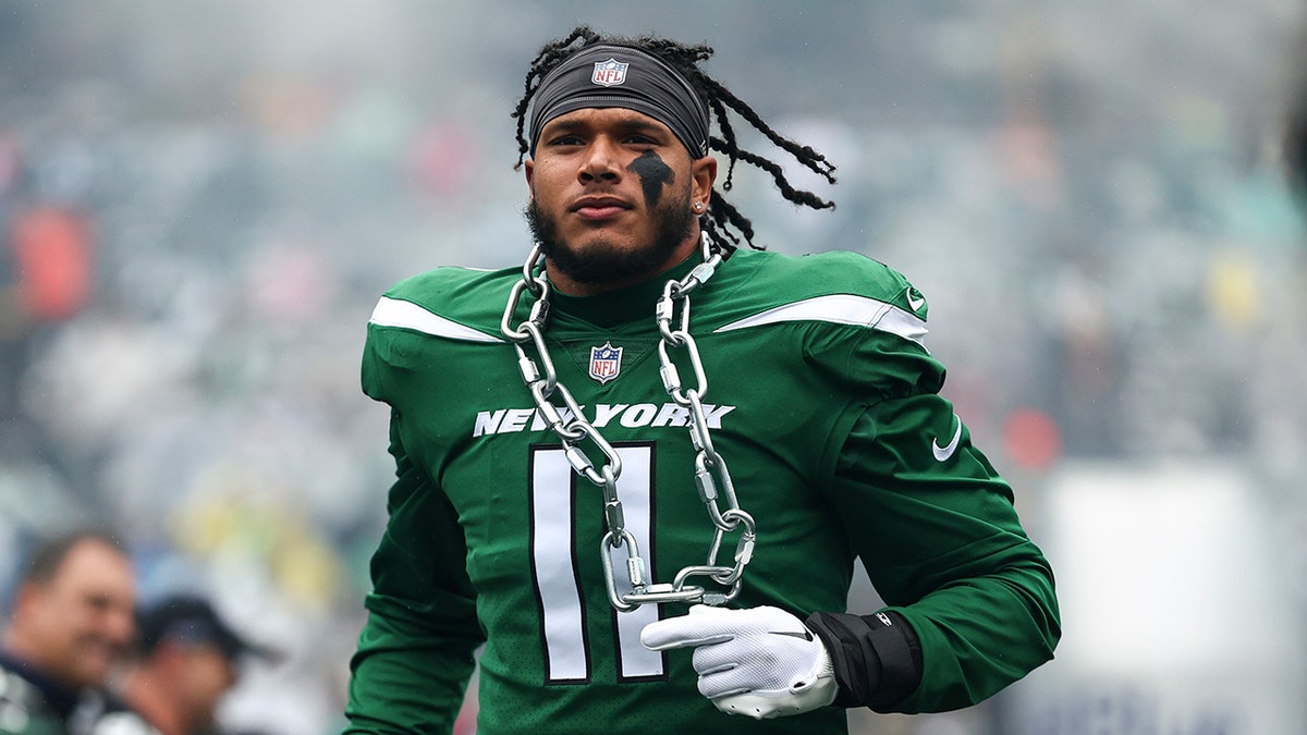 Jermaine Johnson runs on field with chain around neck