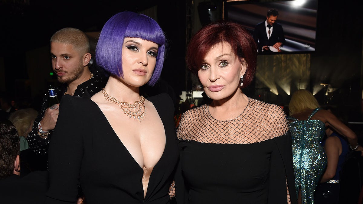 Kelly standing with mother, Sharon Osbourne