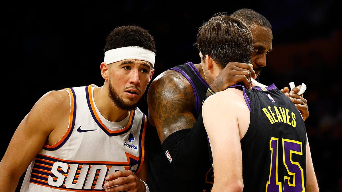 Lakers players talk during a game against the Suns