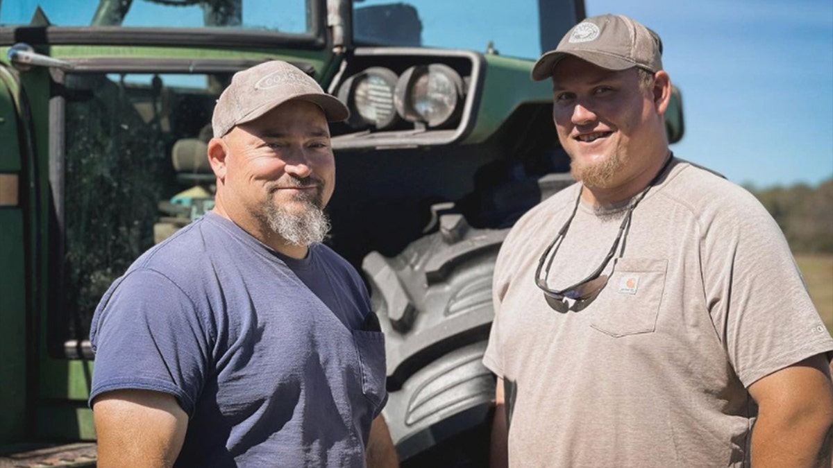 The lindlers pose next to a tractor on their farm.