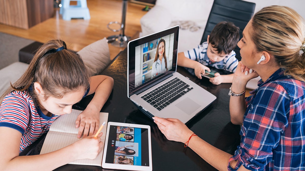 Mom and children on laptops.