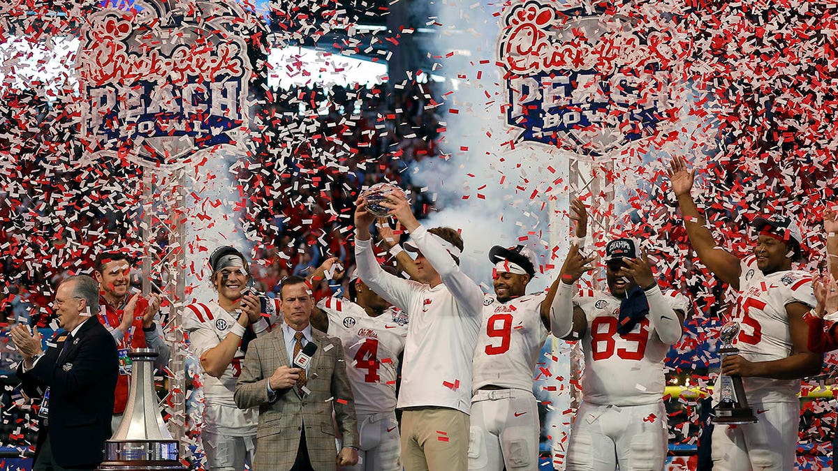Lane Kiffin and Ole Miss players celebrates after a bowl game win