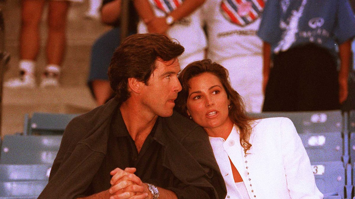 Pierce Brosnan and Keely Shaye Smith sitting in the stands together