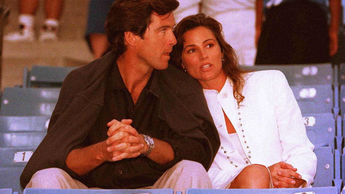 Pierce Brosnan and Keely Shaye Smith sitting in the stands together