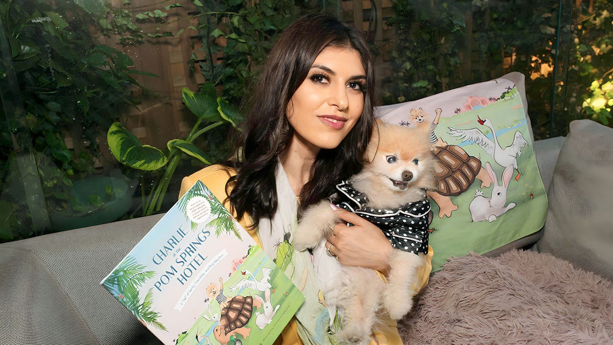 Woman and pom dog wearing shirt