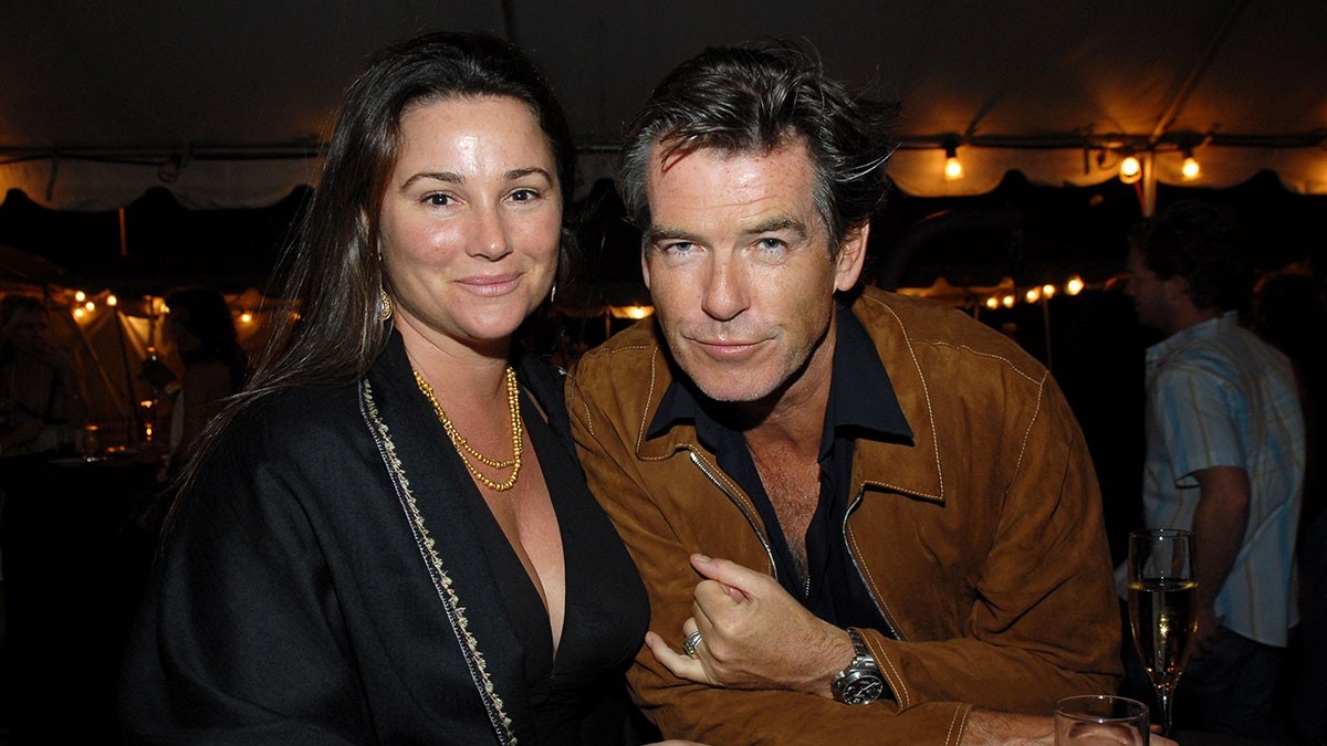 Keely Shaye Smith and Pierce Brosnan leaning in together