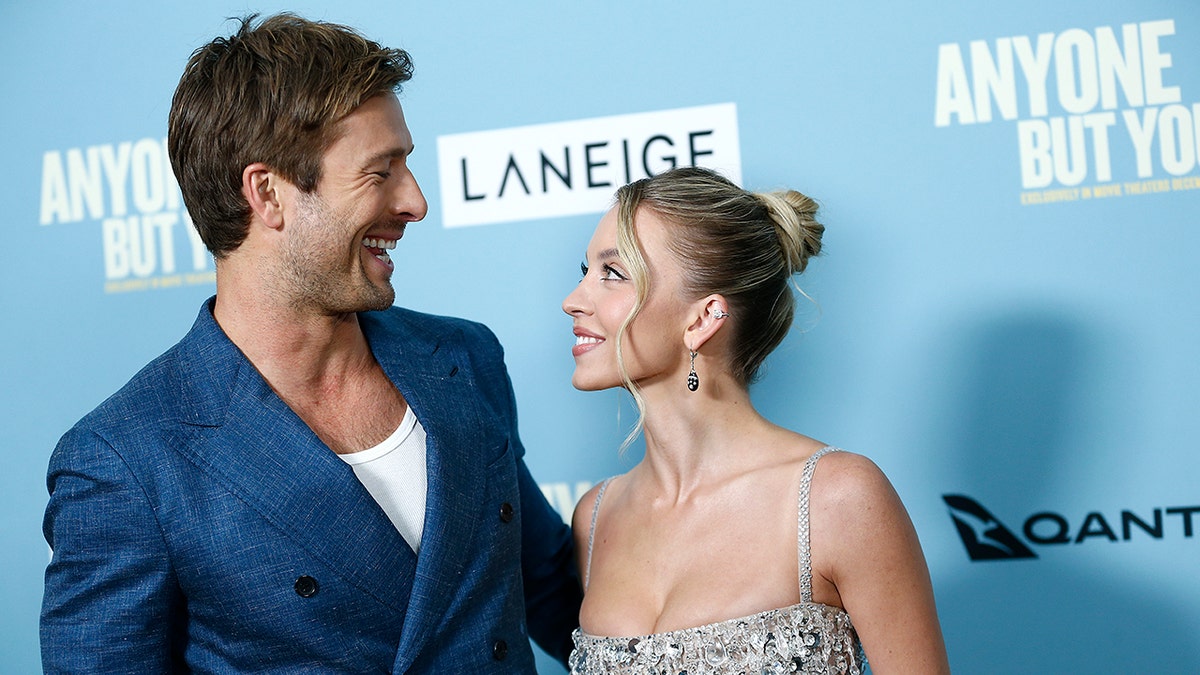 Sydney Sweeney and Glen Powell smile on red carpet