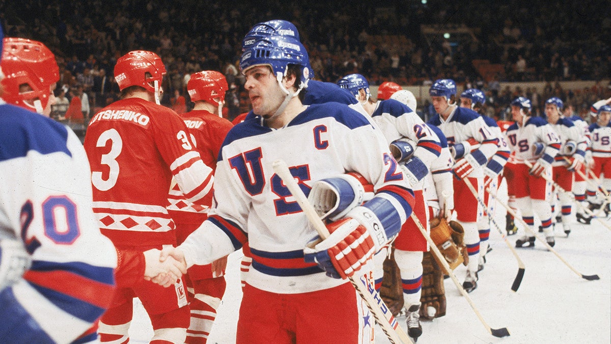 Mike Eruzione shakes hands after a hockey game