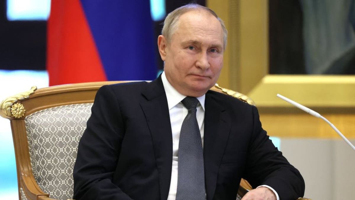 روسی صدر ولادیمیر پوٹن بیٹھے ہیں۔
