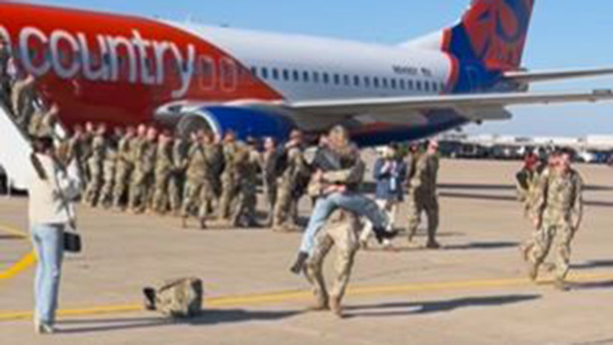 Woman jumps into Nebraska soldier’s arms as troop returns from deployment for Christmas in heartwarming video 2 Woman hugs a soldier returning from deployment