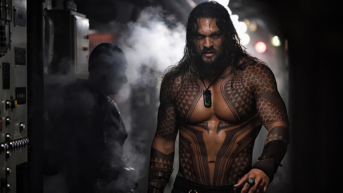 Jason Momoa shirtless with tattoos all over his body as "Aquaman"