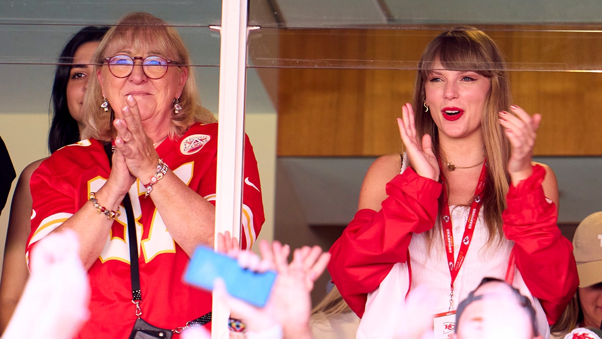 Donna Kelce in a Travis Kelce jersey and Taylor Swift in a red jacket cheer on the Chiefs from a suite