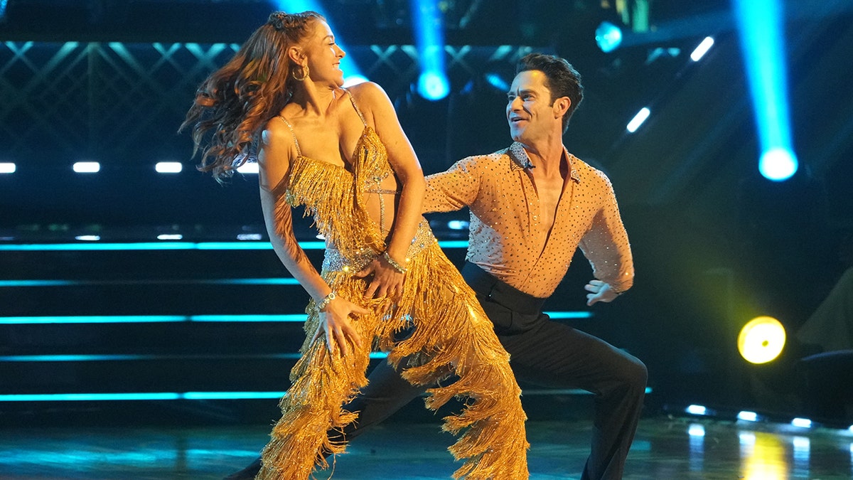 Alyson Hannigan and Sasha Farber both wearing gold outfits dance facing each other on "DWTS"