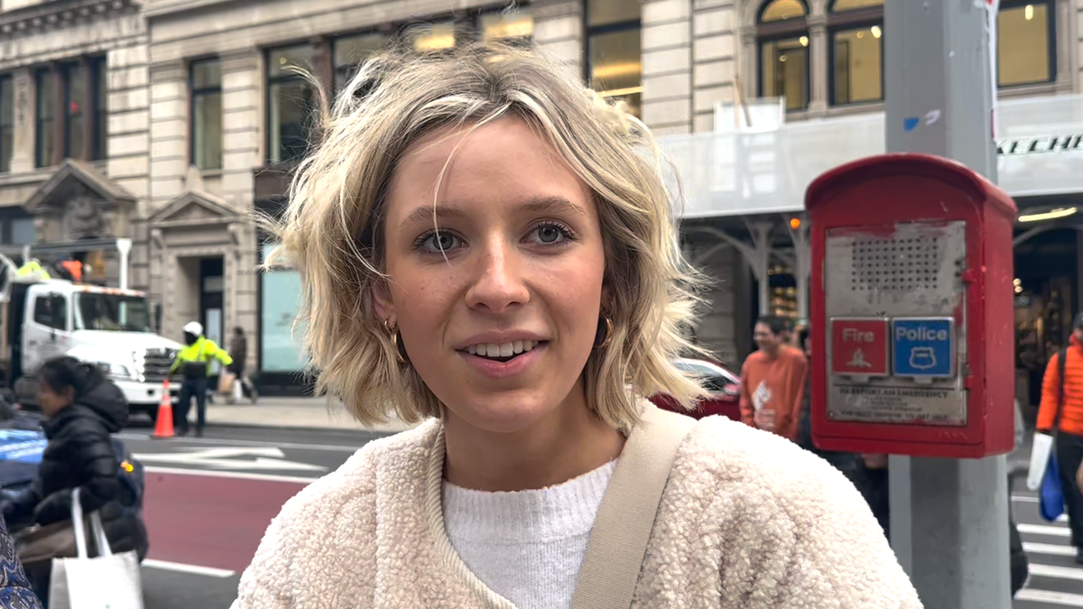 woman stands on sidewalk in new york talking about the best christmas presents