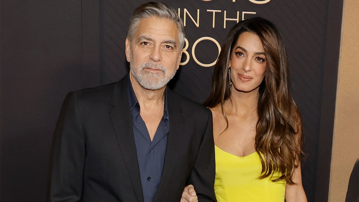 George Clooney wore a black blazer and blue button down next to his wife Amal in a yellow dress