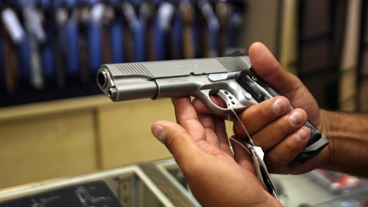 Customer looking at gun in shop