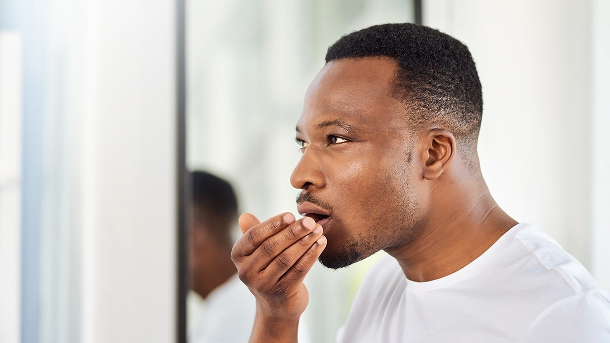 man checks breath