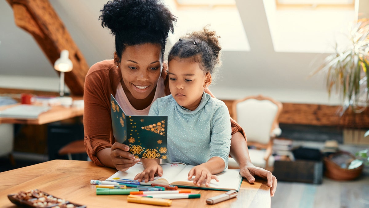 mom reads christmas card to daughter