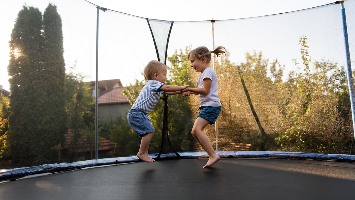 Little kids bouncing off the trampoline taut