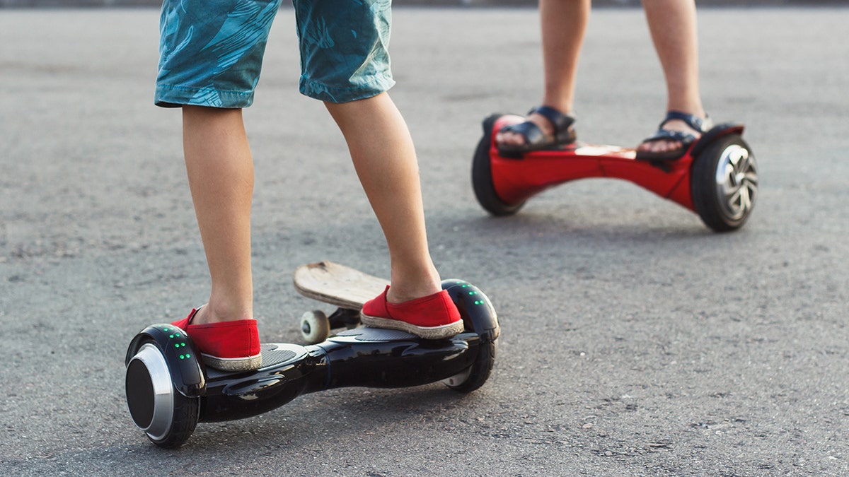 Boys stands on the black gyro scooter outdoors