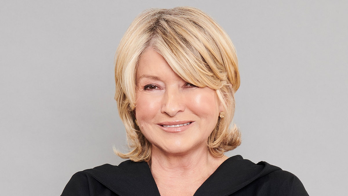 Martha Stewart smiles wearing black jumpsuit