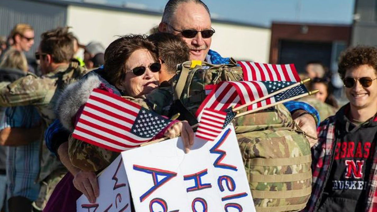 Family hugs solider returning from deployment