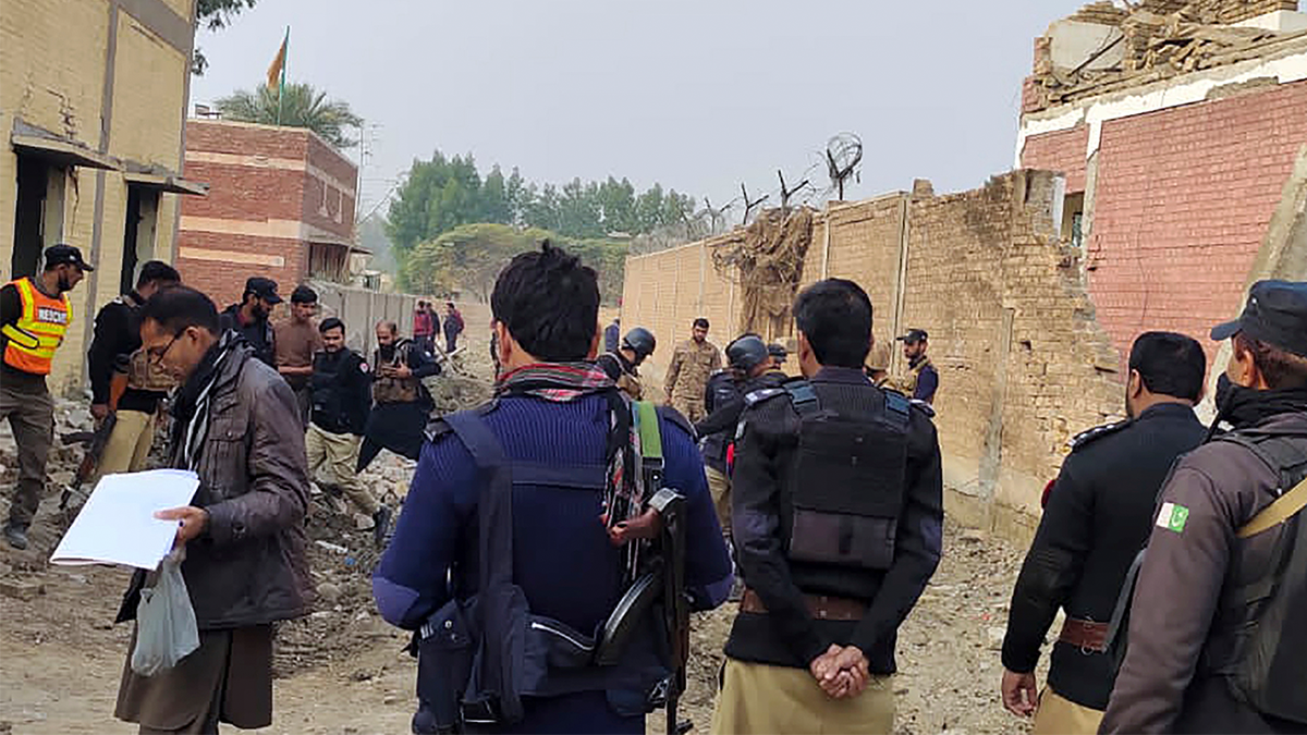 Security officials examine damages on the site of a bombing