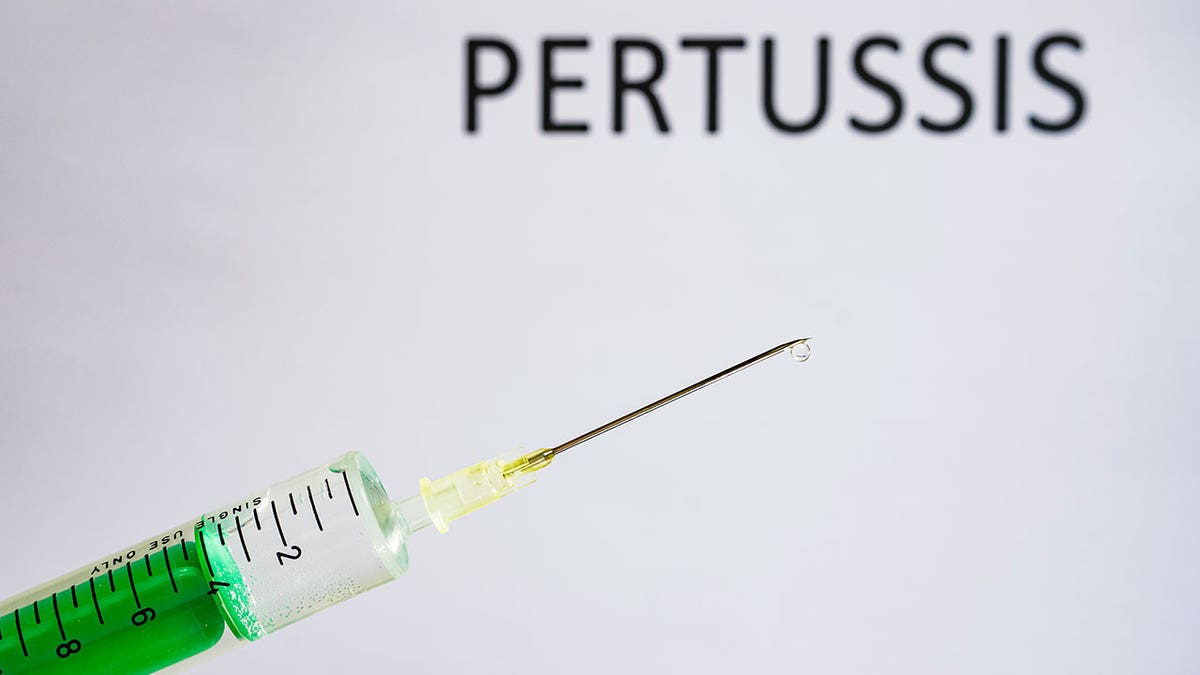 Illustration of a disposable syringe with the word "whooping cough" in the background