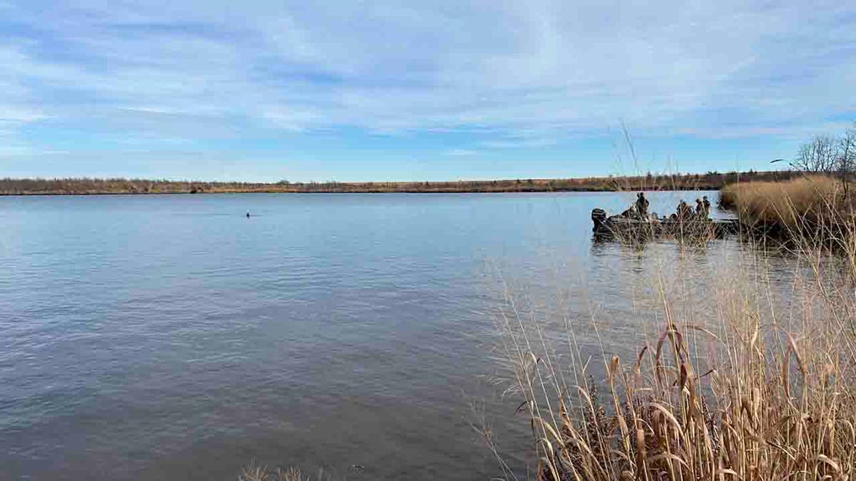 funcionarios en barca en el lago Sooner