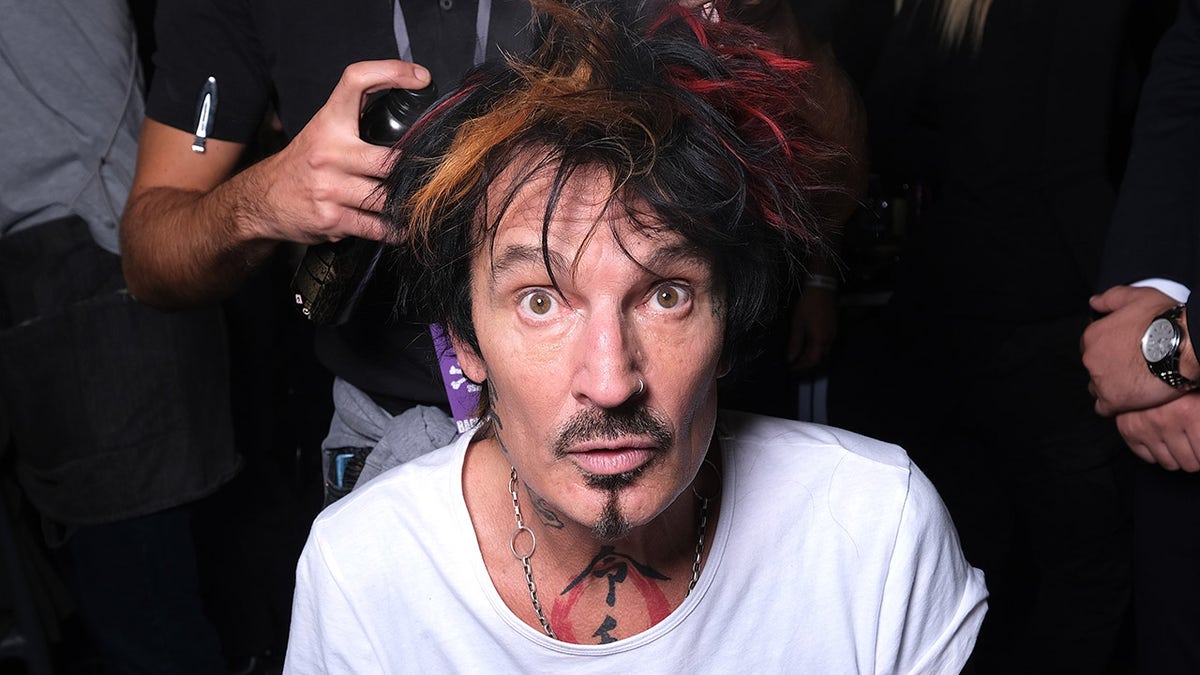 Tommy Lee wearing a white t-shirt at a fashion show